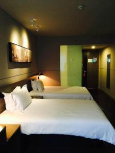 a hotel room with two beds with white sheets at Jinjiang Inn Select Shanghai International Tourist Resort Chuansha Subway Station in Shanghai