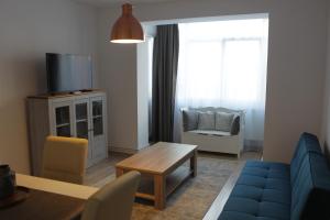a living room with a blue couch and a table at Joy Apartment in Timişoara