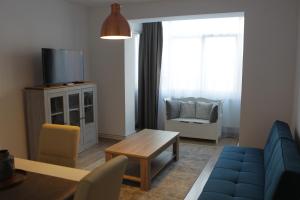 - un salon avec un canapé bleu et une table dans l'établissement Joy Apartment, à Timişoara