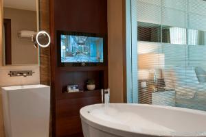a bathroom with a tub and a tv on a window at Elite World Europe Hotel in Istanbul