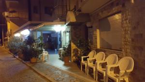 a group of chairs sitting outside of a building at night at Stella del Mare in Sottomarina