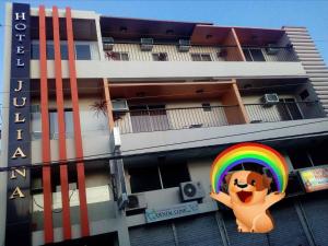 un edificio con una señal de arco iris delante de él en Hotel Juliana, en Tuguegarao
