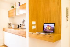 パレルモにあるKalamonjo Suite&Roomsの- ノートパソコン(キッチンの木製棚に座ったパソコン)