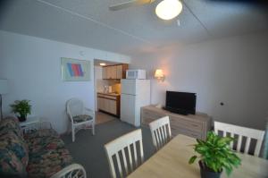 a living room with a couch and a table and a kitchen at Sea Scape Inn in Wildwood Crest