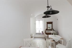 a white dining room with a table and chairs at DUSSAIGA - Camera Del Fiordaliso in Dolceacqua