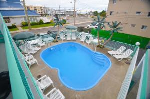 a swimming pool on a balcony with lounge chairs at Sea Scape Inn - A Fine Family Destination in Wildwood Crest +21 photos
