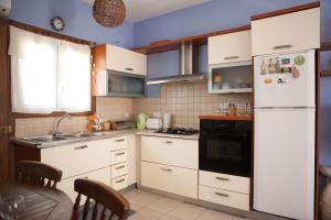 een keuken met witte kasten en een witte koelkast bij Aquarian Beachfront Apartment in Larnaka