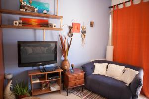 een woonkamer met een blauwe bank en een tv bij Aquarian Beachfront Apartment in Larnaka