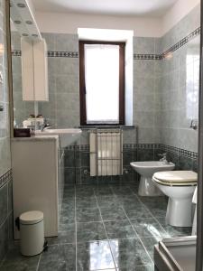 a bathroom with two sinks and a toilet and a window at La casa di nonna Bruna in Muggia