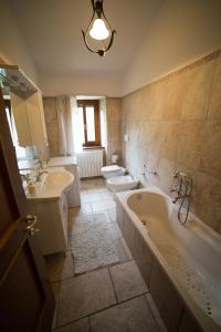 baño con 2 lavabos, bañera y 2 aseos en La Fattoria dei Sibillini, en Montemonaco