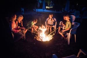 a group of people sitting around a fire at Ferienwohnungen Lindleshof in Leinach +66 photos