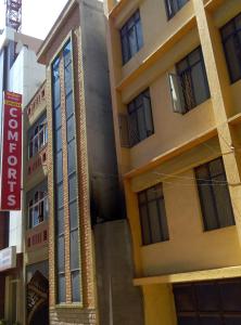 un edificio con una señal delante de él en Suvarna Compact, en Mysore