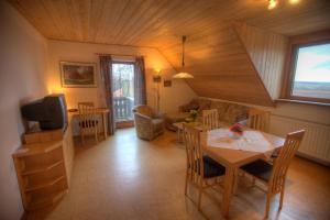 a dining room with a table and chairs in a room at Ferienwohnungen Lindleshof in Leinach