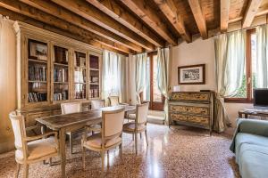 een woonkamer met een houten tafel en stoelen bij Casa Contarini in Venetië