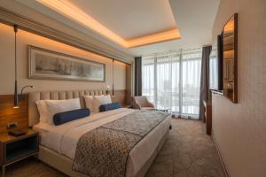 um quarto de hotel com uma cama e uma grande janela em Golden Tulip Istanbul Bayrampasa em Istambul