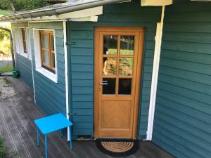 ein blaues Haus mit einer Holztür und einem blauen Tisch in der Unterkunft Ferienhaus Momo in Nieder-Kinzig