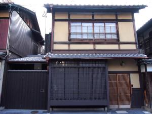 ein altes Haus mit einem Tor und einem Gebäude in der Unterkunft Ichimatsu-an in Kyoto