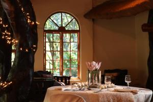 a table with a white table cloth and a window at iNsingizi Lodge in Mid Illovo