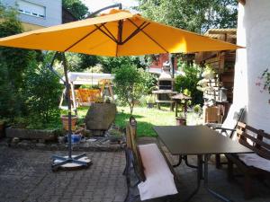 een gele parasol op een patio met een tafel bij Ferienwohnung bei Michels in Ober-Kinzig