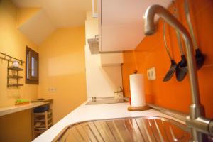 Una cocina con fregadero y paredes naranjas. en Casa Garrote, en Cuenca 61 fotos más