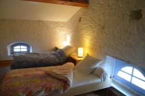 a bedroom with a bed and a couch and two windows at Les Roses d'Autan in Auriac-sur-Vendinelle