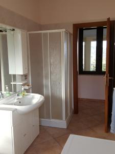 uma casa de banho com um lavatório branco e um chuveiro em Villa Carmen em Cardedu