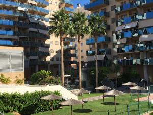 a row of umbrellas in front of a building at Abedules in El Campello