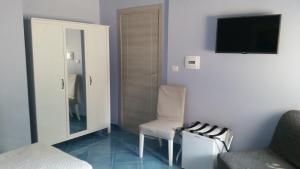 a living room with a chair and a television at Piccolo Bed in Procida