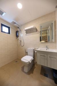 bagno con servizi igienici, lavandino e specchio di M&M Hotel a Kuala Lumpur