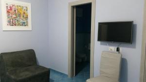 a living room with a chair and a television at Piccolo Bed in Procida +15 photos