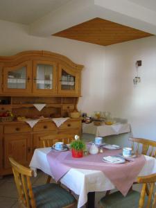 a kitchen with a table with a pink table cloth at Haus am Brunnen in Umhausen