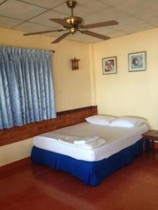 Cama en habitación con ventilador de techo en Tropicana Khophagan Resort Hotel en Thongsala
