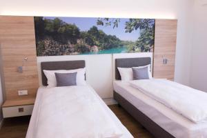 2 camas en una habitación con un cuadro en la pared en Boardinghouse am Teuto en Lengerich