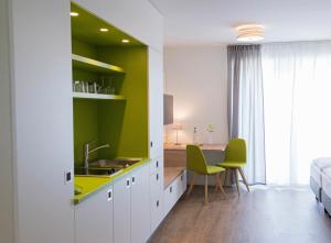una cucina con lavandino e una scrivania in una stanza di Boardinghouse am Teuto a Lengerich