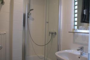 y baño con ducha y lavamanos. en Hotel Garni Alte Post, en Boffzen