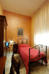 a bedroom with a red bed and a television at Albergo Bellavista in Latina