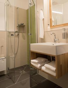 ein Bad mit einem Waschbecken und einer Dusche in der Unterkunft Hotel Christophorus in Berlin