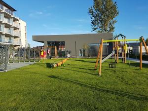 a playground with slides and swings in front of a building at Apartament Nadmorski - Kompleks Pięć Mórz z basenem in Sianozety