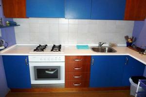 a blue and white kitchen with a stove and a sink at Apartamento Playa in Denia