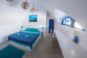 Dormitorio blanco con cama azul y lavamanos en Bali Bio Villas, en Uluwatu