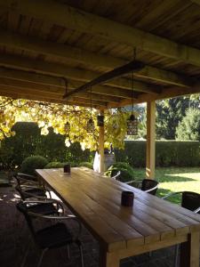 einen Holztisch und Stühle unter einer Pergola in der Unterkunft B&B Le Secret Du Bois in Bourseigne-Vieille