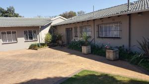 a house with a brick driveway in front of it at 8 Ibis Lane Guest House in Johannesburg
