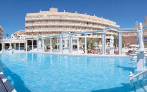 a large swimming pool in front of a hotel at Hotel Cleopatra Palace in Playa de las Americas