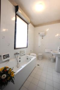 a bathroom with a tub, toilet and sink at Hotel Excelsior in Latina