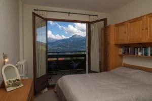 a bedroom with a bed and a view of a mountain at Mont Blanc Views Apartments in Passy