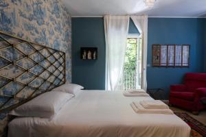 ヴェローナにあるPalazzo Fracastoroのベッドルーム1室(大型ベッド1台、赤い椅子付)