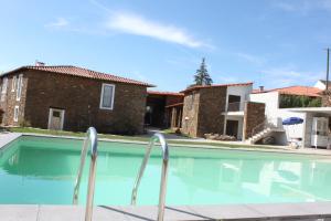 a swimming pool in a house with two buildings at Agroturismo Casal de Castro in Mirandela