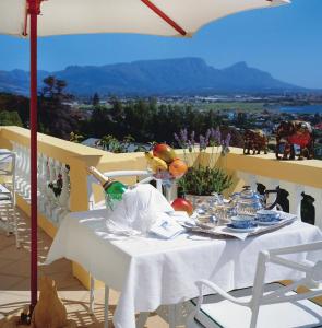 a table with a white table cloth on a balcony at Colona Castle in Lakeside