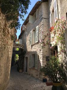 an alley in an old stone building with flowers at L'élégante - maison de ville avec bains à remous - parking inclus in Saint Paul de Vence