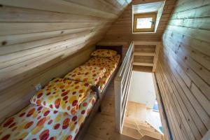 a bedroom with two beds in a wooden room at Gradačka Banja brvnare in Gradac